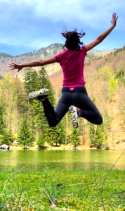 Luftsprung einer Frau vor einem See